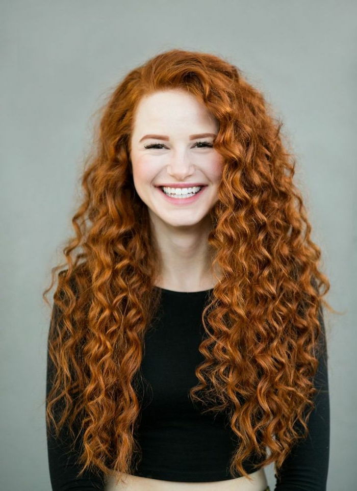 Langt, naturlig rødt hår, med krøller, god hud, rosa lepper, svart topp, fint smil