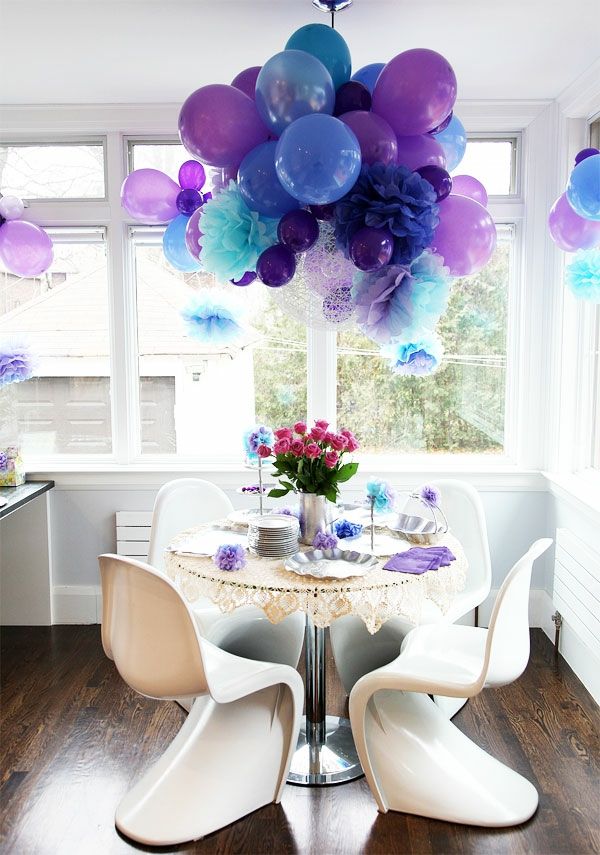 Balões pendurados no teto como decoração no pequeno quarto - azul e roxo