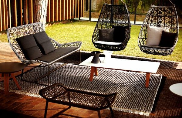 modern vormgegeven met mandhangende stoelen in de tuin
