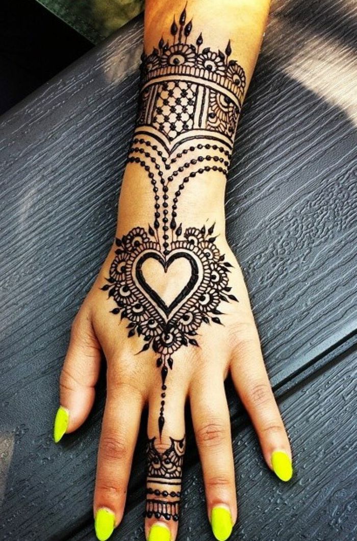 tatoveringsmotiver kvinne anstendig tatovering henna på hånden av en vakker kvinne som maler gule negler