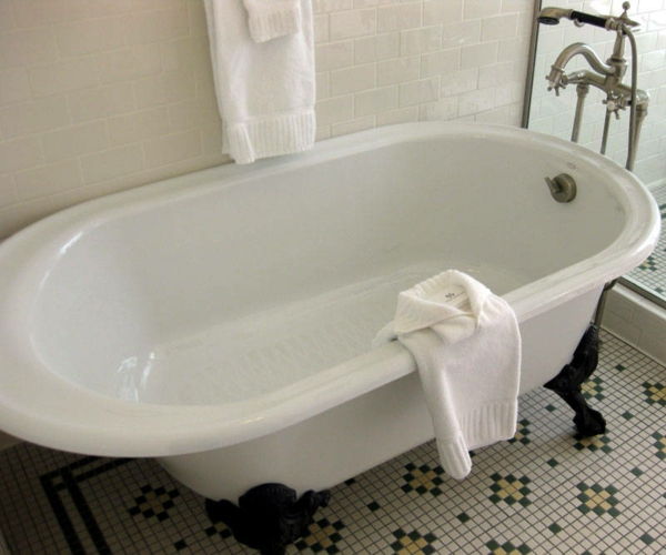 vakkert hvitt badekar på badet med hvit veggdesign