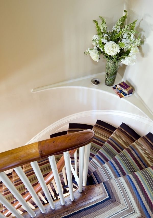 gražus ir elegantiškas laiptai su kilimu - šalia jo yra baltos gėlės