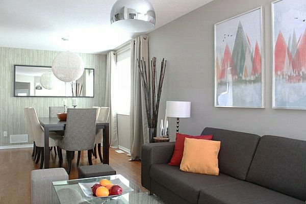 vakker-stue-farge Dark-sofa-med-en-orange-Pillow-og-grå-vegg-med-bilder