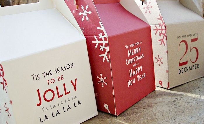 Kartonglådor som viks av sig själv med julmeddelanden i vit och röd färg