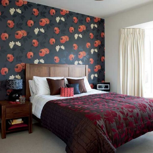 rdeče in okrske slike na sivi steni v spalnici