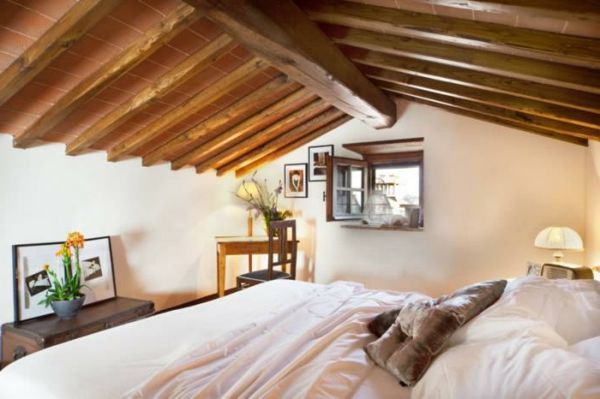 schlafzimmer_mansarda-med-trä tak och vita väggar