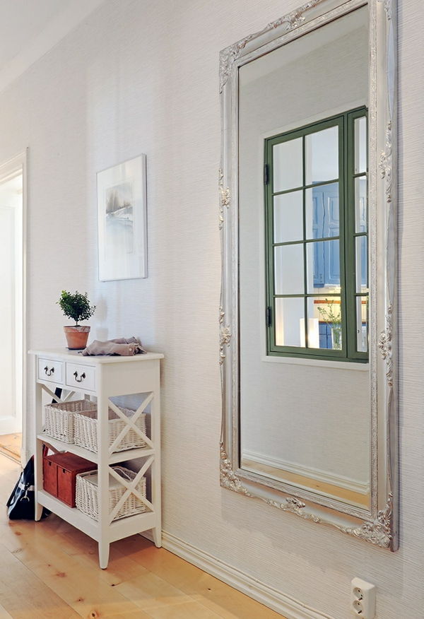 vit design i korridoren med en stor lyxspegel