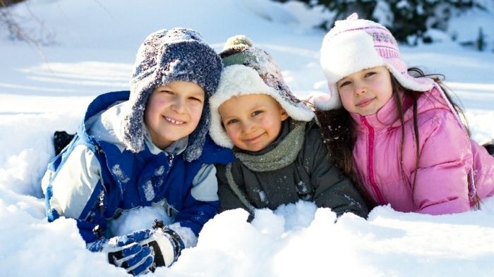 Tre barn har det gøy i snøen - de skal ri på en slede