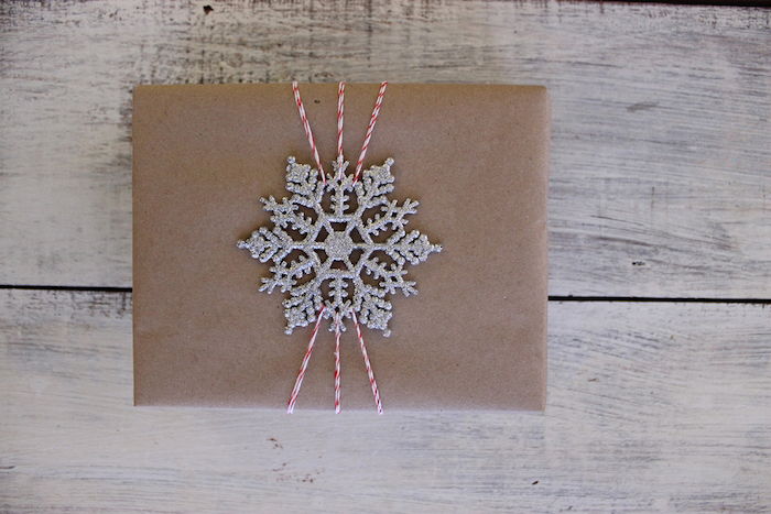 Tinker Winter - darček s hnedým papierovým obalom a striebornou vločkou ako dekoráciou