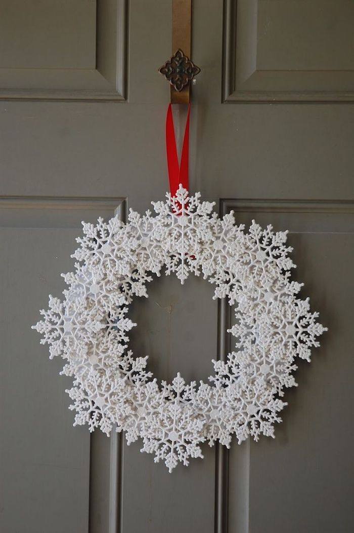 dverový veniec na Vianoce v bielej farbe upevnenej červenou stuhou - snehové vločky obrázky