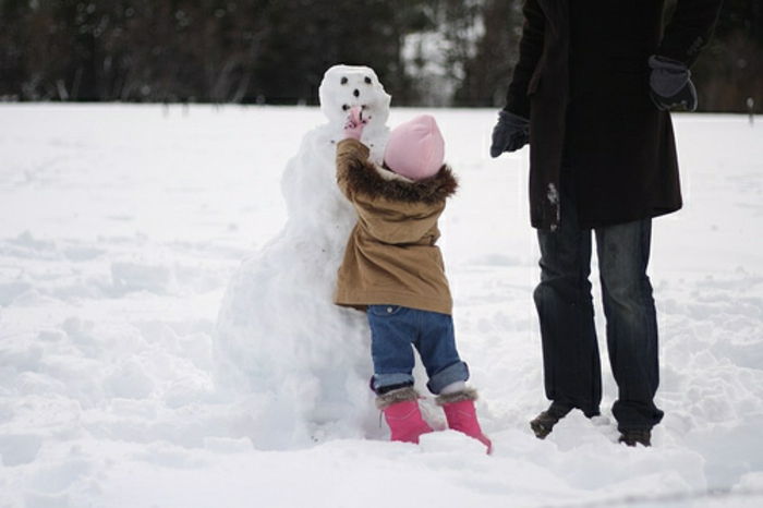 unik snømann - et lite barn bygger
