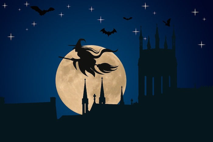 Halloween pozadia - čarodejnice na metlu letí cez stredoveké mesto