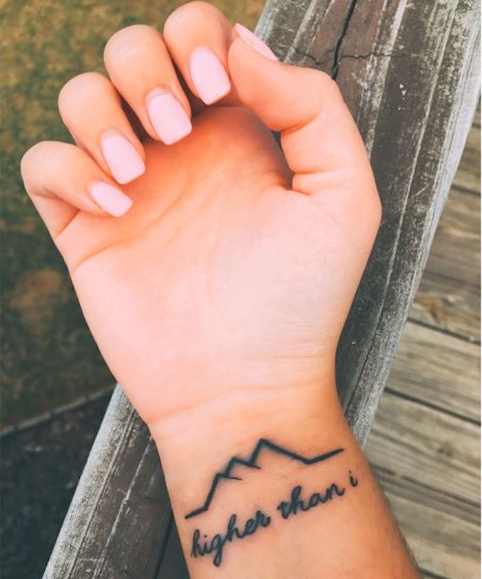 o linie întreruptă sub formă de munți și cu litere de tatuaj pe încheietura mâinii