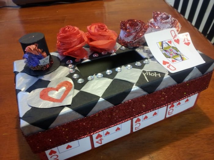 Dėžutėje puošia rožės magas ir maža skrybėlė su žaidimo kortomis