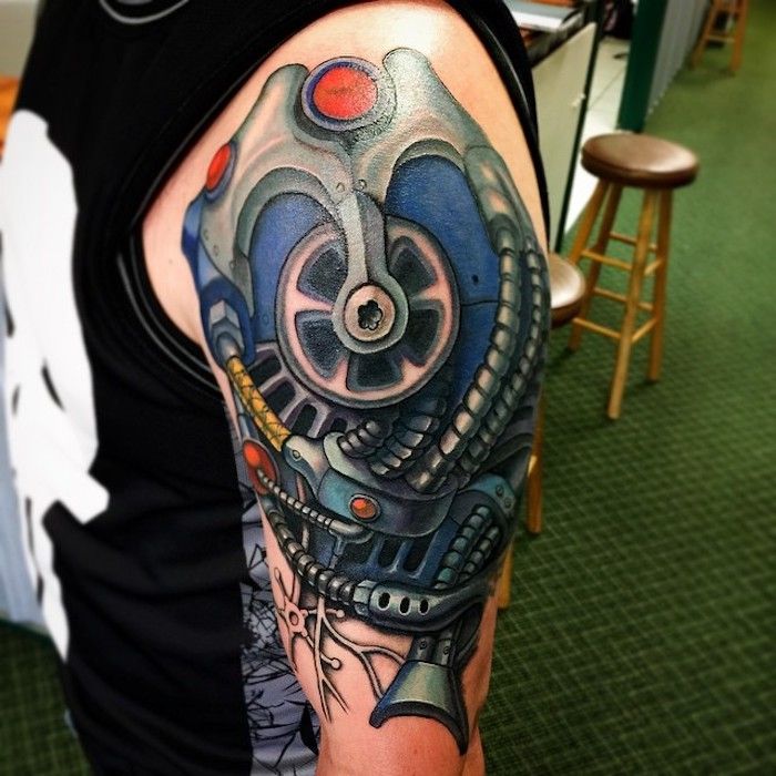 moški z barvnim tattooom v nadlakti, tatoo z deli stroja