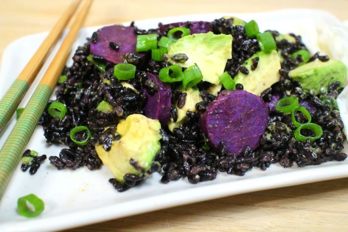 svart ris matlagning ris med avokado grönlök lök äta maten med ätpinnar