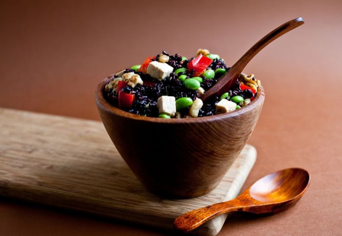 svart riskock i skål serverar veganska recept för att njuta av ris tofu paprika trä