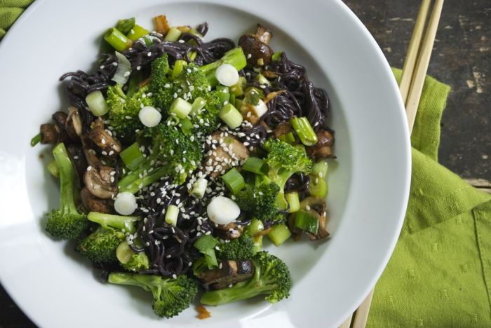 svart ris kock grön platta form mat med broccoli lök med ätpinnar mat