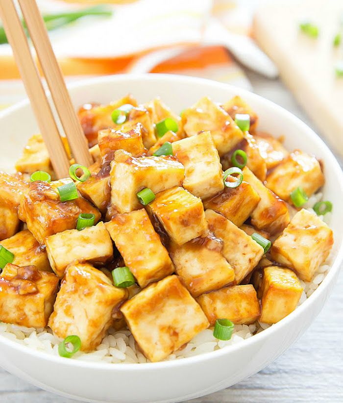 Seidentofu oppskrift å prøve marinert tofu tallerken med ris og friskt løkgrønne blader bolle over hvitt