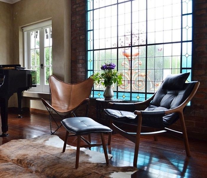 Obývacia izba s tehlovou stenou, štvorcové okno s krásnym farebným sklom, luxusný nábytok