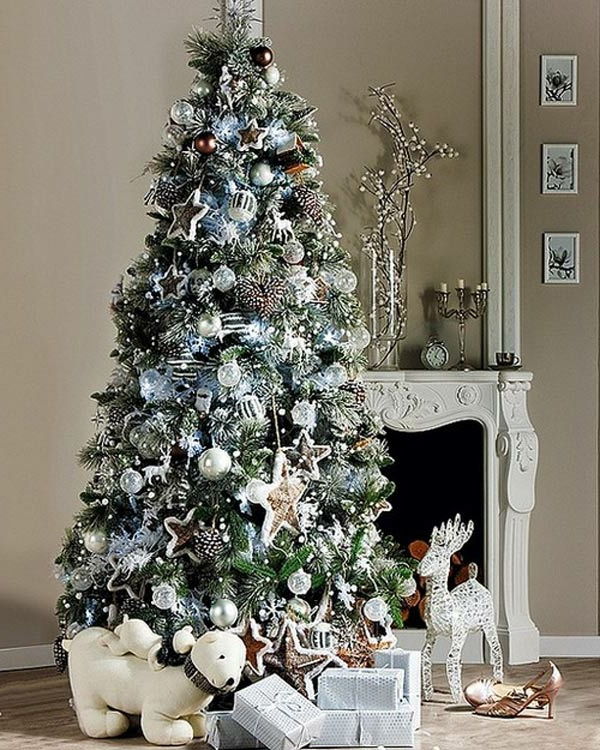hvit juledekorasjon - elegant peis og et stort juletre ved siden av det