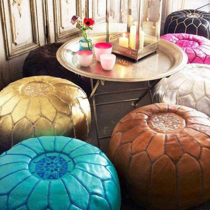 Medinė sienų apnaša su pasenusiomis išvaizdomis, apvalus metalinis stalas su aukso danga, žvakė ir gėlių deko, daugybė odos spalvos kontūrinių spalvų