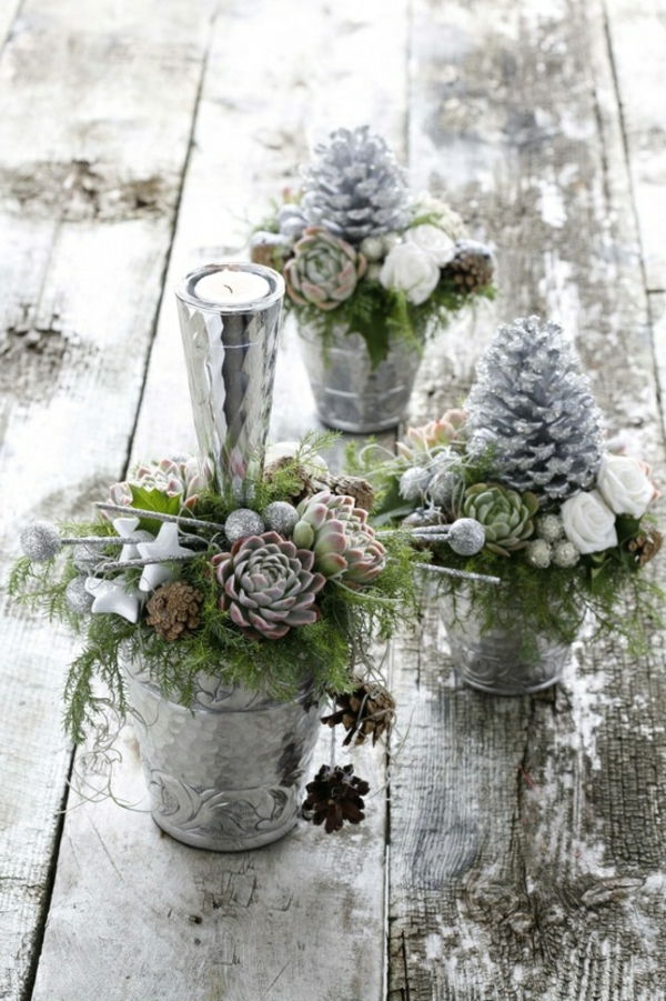białe świąteczne dekoracje - piękne kwiaty, białe szyszki i mała świeca