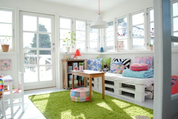 soffa-på-pall-i-rum-med-vit-design-grön matta