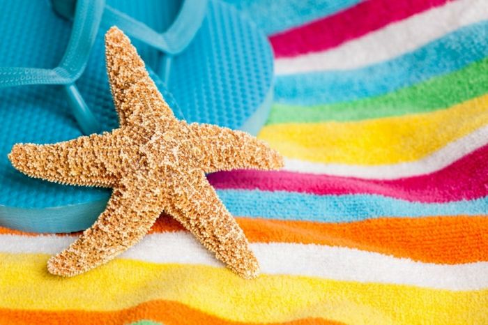 sommerstemning sjøstjerner-strandhåndkle-farget striper og blå flip-flops
