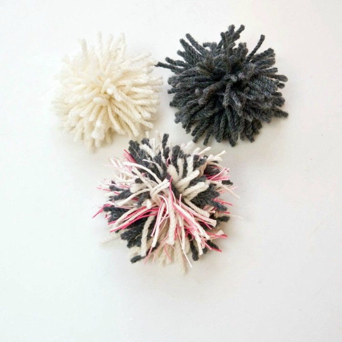 Tre pompom i svart, vit och rosa färg - gör kattleksaker snabbt och enkelt