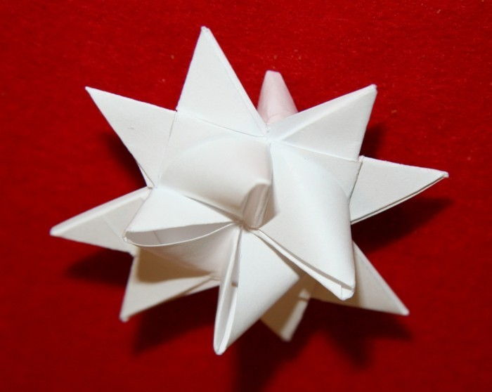 star-fold-out papir-hvitt-tipp-modell-rød-bakgrunn