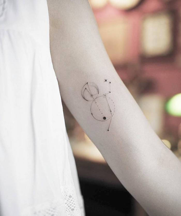 ideja za tetovažo za ženske - roka s tetovažo s črno malo zvezdno sliko s črnimi zvezdicami in luni
