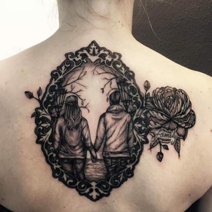 Blackwork-tattoo op de achterkant van twee zussen tatoeages voor zussen met een opschrift Familie