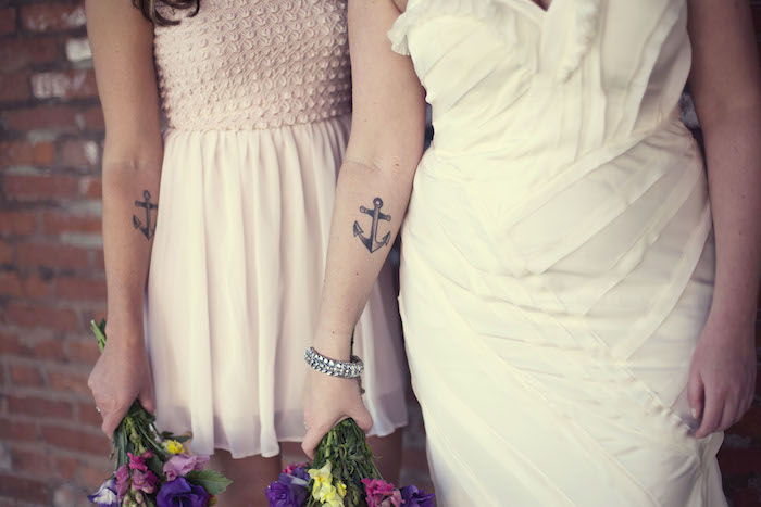 Ankerkatoegering op de armen van twee zussen op de trouwdag van een tatoeage voor zussen