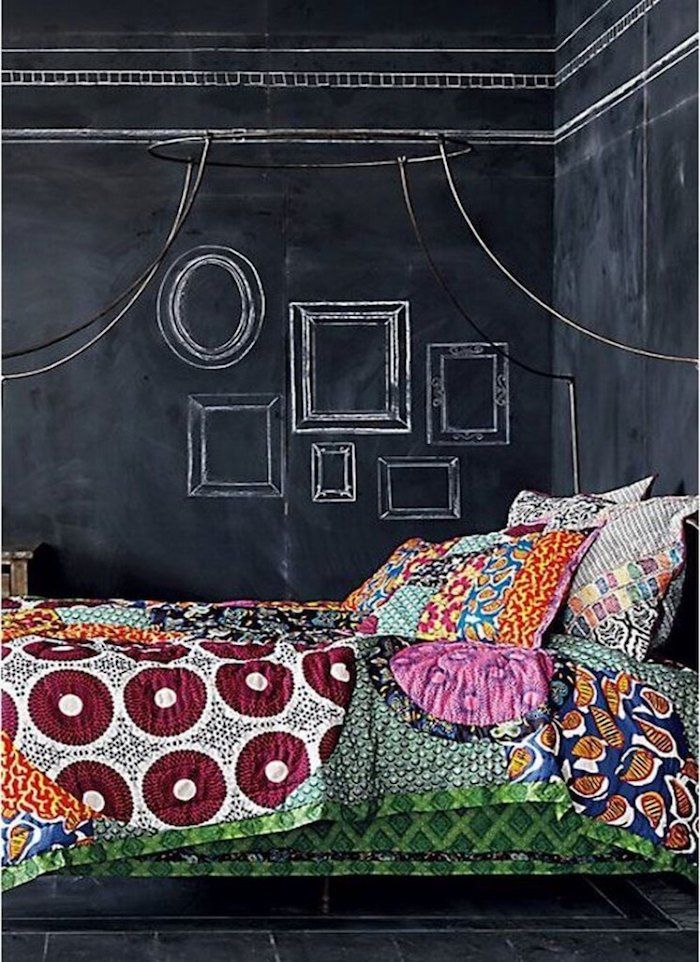 stena s črno barvo, poslikane okvirje za slike zgoraj, postelja z barvitimi listi