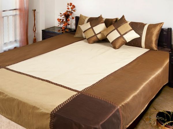 sängsäck-i-brunt-på-en-stor-säng - vackert kasta kudde