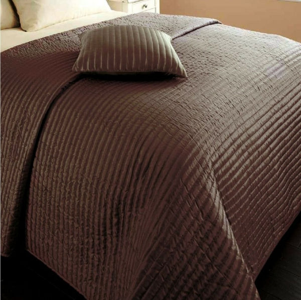 sprei-in-bruin-foto-genomen-dichtbij-het-bed - kussens gooien op het bed