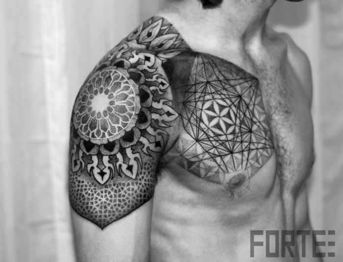 Técnica old-school e new-school unifica, tatuagem ornamental geométrica no ombro e no peito de um jovem com cabelo no peito