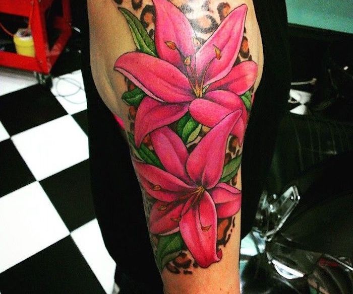Tattoo betekenis, grote gekleurde tatoeage met roze lelies