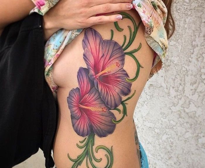 tattoo grote gekleurde bloemenrank aan de lichaamszijde