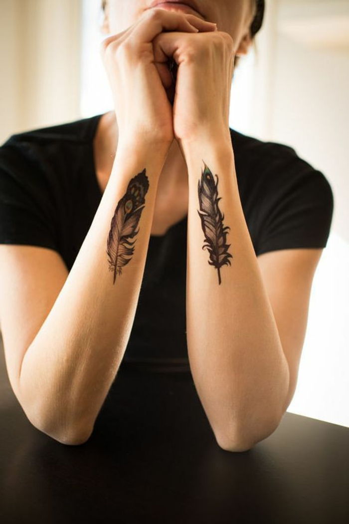 tatovering mønster ide fjær deco på de to armer svart t-skjorte kvinne subtil ide tatovering