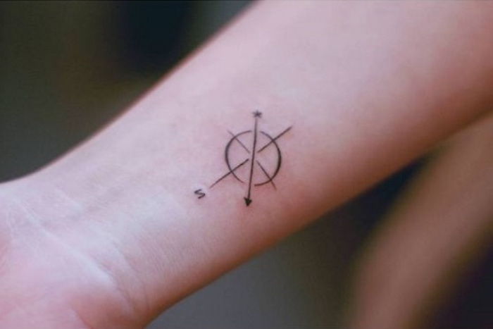 mici tatuaj frumos pe încheietura mâinii cu busola și săgeți mici negru