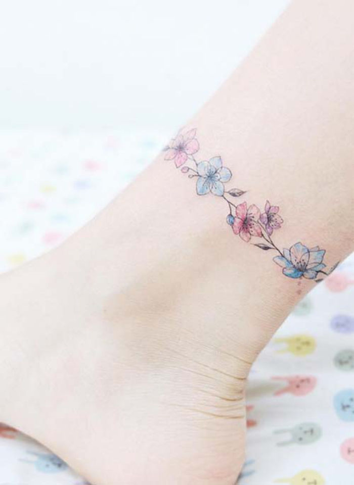 tatuering på fotleden, små blommor, kvinnliga tatueringsmotiv, bentatuering