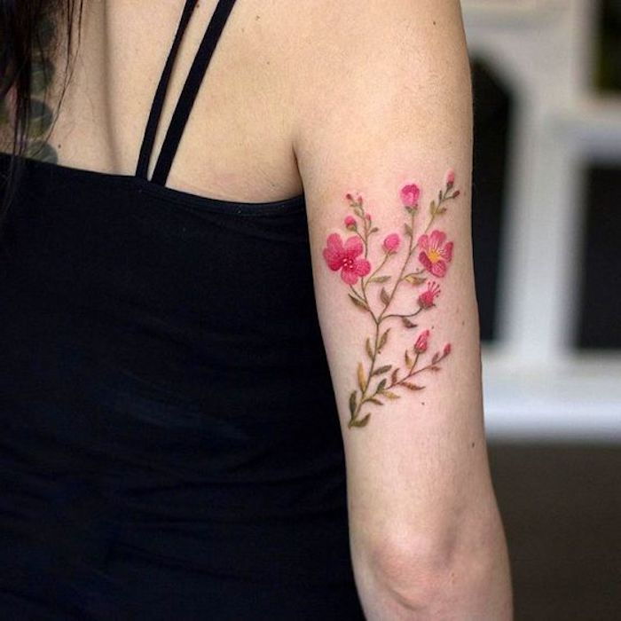 Gėlių tatuiruotė, rožinės gėlės su žaliais lapais, viršuje su diržais