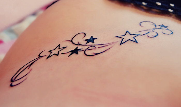 malé tetovanie s malými čiernymi a veľkými bielymi hviezdičkami - tetovacie hviezdy pre ženy