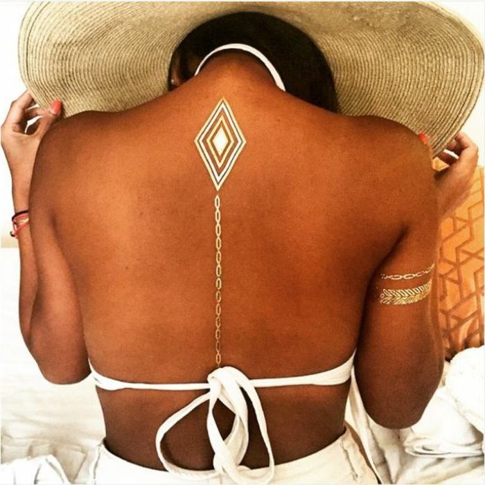 tatuiruotės moteris padorus tatuiruotė ant nugaros grandinės formos linijos balta maudymosi kostiumėlė auksiniai apyrankės