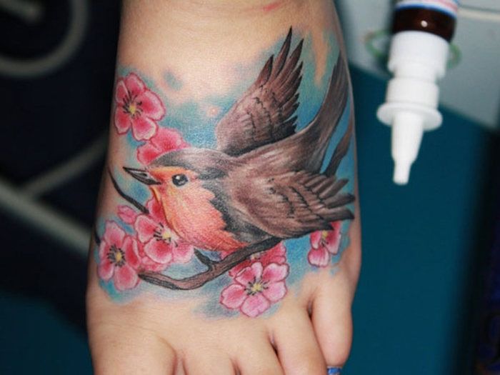 tatuaj flori de cireșe, pasăre constructor pe ramură, tatuaj colorat pe picior