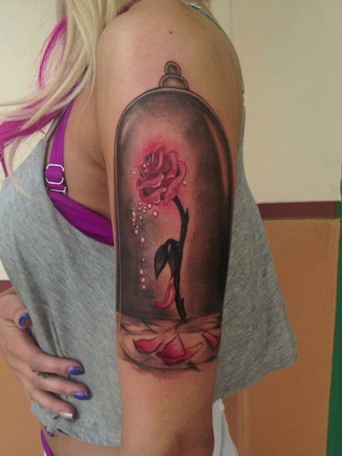 pomysł na różowy tatuaż na ręce - różowa róża z baśniowymi motywami - piękna i bestia - kobieta z różowym tatuażem
