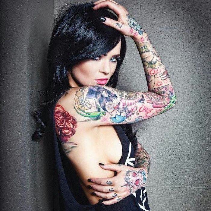 vrouw met tatoeages, zwart krullend haar, kleurrijke tatoeages