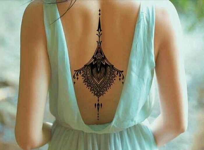 tatovering motiv tilbake med svart tatovering dekorere kvinne med vakker blå kjole åpen tilbake